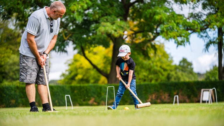 A father and son enjoying a game of croquet on the lawns of Wimpole Estate, Cambridgeshire